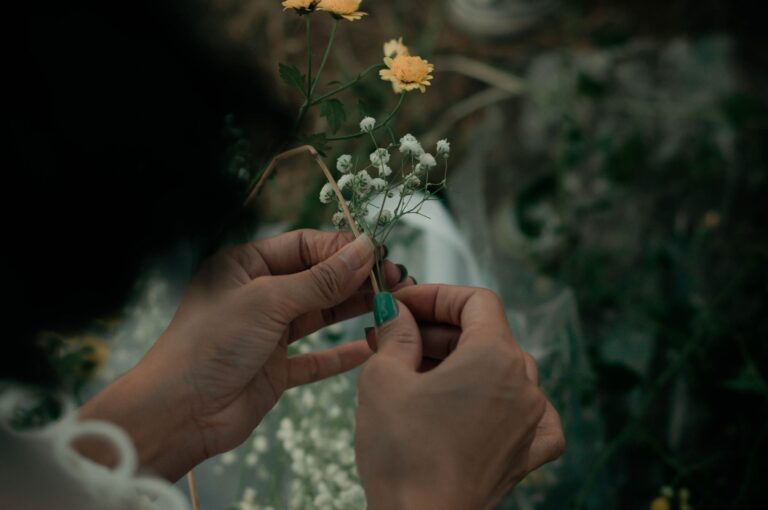 Hands pinching flower