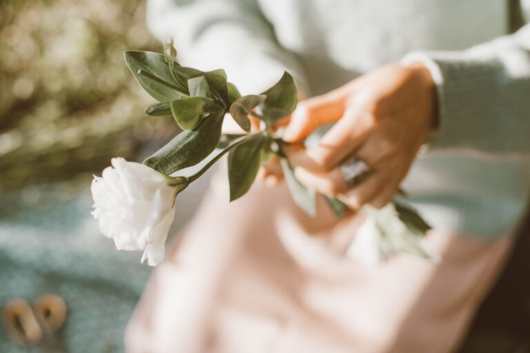 Hands pinching flower